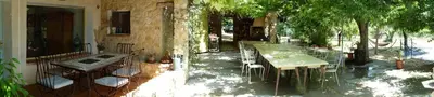 a patio with tables and chairs in a garden at Maison à Ansouis Luberon in Ansouis