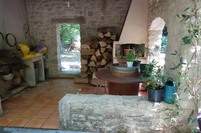 a room with a table and a pile of wood at Maison à Ansouis Luberon in Ansouis