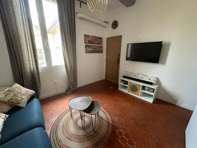 a living room with a blue couch and a tv at Cosy apartment Right in Cours Mirabeau in Aix-en-Provence