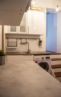 a kitchen with white cabinets and a sink at Cosy apartment Right in Cours Mirabeau in Aix-en-Provence