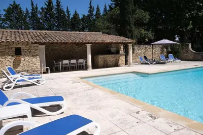 a swimming pool with lounge chairs and a pavilion at Provencal Farm with swimming pool near Isle sur la Sorgue - 10 people. in Les Vignères