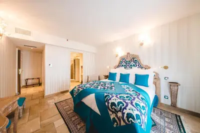a bedroom with a blue and white bed in a room at Le Palais d'Aglaé, Hôtel de Charme in Gordes