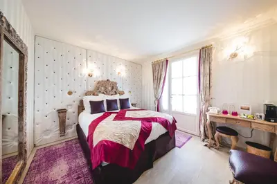 a bedroom with a bed and a desk and a window at Le Palais d'Aglaé, Hôtel de Charme in Gordes