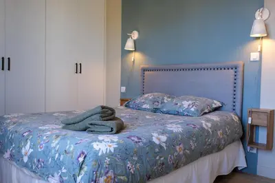 a bedroom with a bed with a blanket and pillows at Appartement 2 Queenbed parking clim wifi in Aix-en-Provence