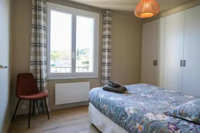 a bedroom with a bed and a window and a chair at Appartement 2 Queenbed parking clim wifi in Aix-en-Provence