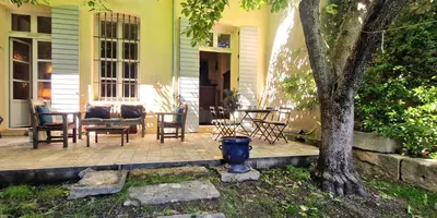 a porch with a table and chairs and a tree at Le Jardin secret 100m Mairie in Aix-en-Provence