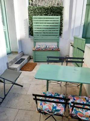 a patio with two chairs and a table and a bench at Appartement Au Murmure des Eaux à Fontaine-de-Vaucluse in Fontaine-de-Vaucluse