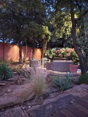 a garden with a bench and trees and plants at Location indépendante au cœur des Alpilles pour 2 personnes avec Jacuzzi in Aureille