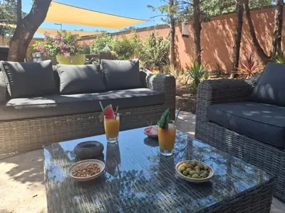a patio with a couch and a table with drinks on it at Location indépendante au cœur des Alpilles pour 2 personnes avec Jacuzzi in Aureille