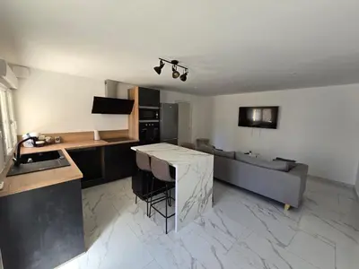 a kitchen and living room with a couch and a table at Pic chic in Châteaurenard