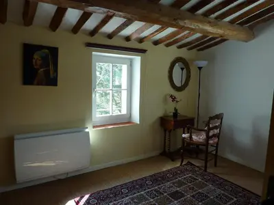 a room with a window and a chair and a mirror at La Grange des Davids Mas en Provence in Oppedette