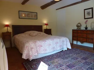 a bedroom with a bed and a dresser and two lamps at La Grange des Davids Mas en Provence in Oppedette
