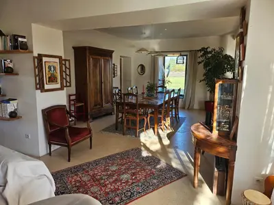 a living room with a dining room table and chairs at Mas des Grialou, grand mas provencal de standing in Carpentras