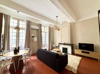a living room with a couch and a table at Splendide T2 au coeur d'Aix et du Cours Mirabeau in Aix-en-Provence