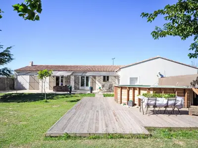 a backyard with a wooden deck in front of a house at Holiday Home L' amandier by Interhome in Saint-Didier