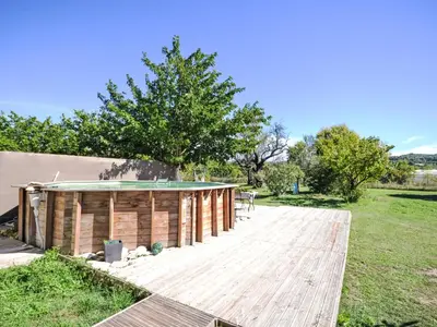 a wooden deck with a pool in a field at Holiday Home L' amandier by Interhome in Saint-Didier