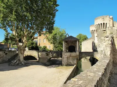 a bridge over a river next to a castle at Holiday Home L' amandier by Interhome in Saint-Didier