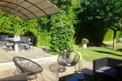 a patio with a table and chairs and an umbrella at Maison avec piscine au calme au pied du Ventoux in Mazan
