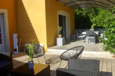 a patio with two chairs and a table and a dining room at Maison avec piscine au calme au pied du Ventoux in Mazan