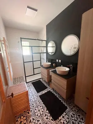 a bathroom with two sinks and two mirrors at Maison avec piscine au calme au pied du Ventoux in Mazan