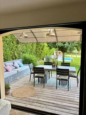 a patio with a table and chairs and a couch at Maison avec piscine au calme au pied du Ventoux in Mazan