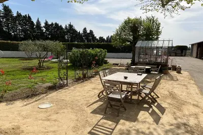 a table and chairs sitting in a yard with a garden at 