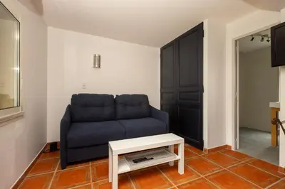 a living room with a blue couch and a table at SmartStay Mas Les Cedres - Proche Isle-sur-la-Sorgue in Lagnes