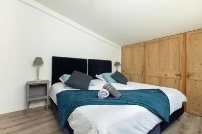 a bedroom with a large bed with a blue blanket at SmartStay Mas Les Cedres - Proche Isle-sur-la-Sorgue in Lagnes