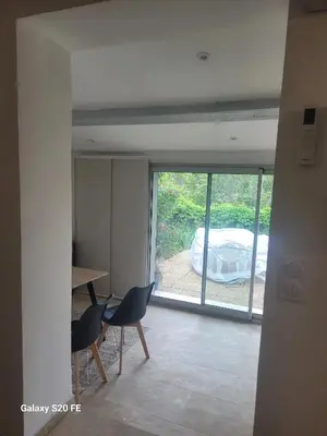a room with a large window and a table and chairs at Maison charmante à Saint-Michel-l'Observatoire avec jardin in Saint-Michel-lʼObservatoire