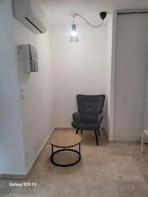 a chair and a table in a room with a lamp at Maison charmante à Saint-Michel-l'Observatoire avec jardin in Saint-Michel-lʼObservatoire