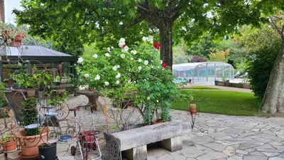 a park with a bench and flowers and a greenhouse at Le Coin Retro pour séjour romantique avec piscine chauffée in Le Thor