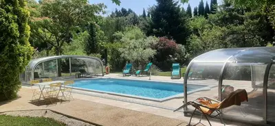 a person sitting in a chair next to a swimming pool at Le Coin Retro pour séjour romantique avec piscine chauffée in Le Thor