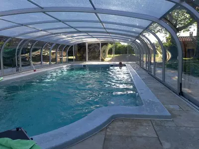 a swimming pool with an open structure with water in it at Le Coin Retro pour séjour romantique avec piscine chauffée in Le Thor