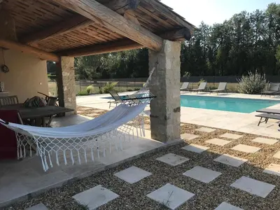 a hammock on a patio next to a pool at Mas Chamsomat in Robion en Luberon