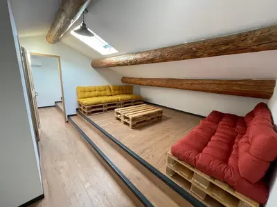a living room with a red couch and two yellow chairs at Mas Chamsomat in Robion en Luberon