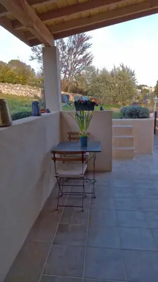 a table and a chair on a patio at Le jardin des oliviers in Apt