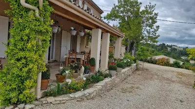 a house with potted plants on the side of it at Le jardin des oliviers in Apt