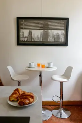 a table with a plate of croissants and two stools at Cocon provençal dans le centre historique in Aix-en-Provence