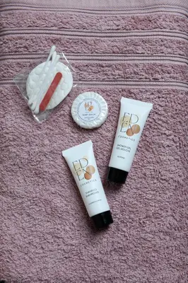 two tubes of sunscreen sitting on a pink blanket at Cocon provençal dans le centre historique in Aix-en-Provence