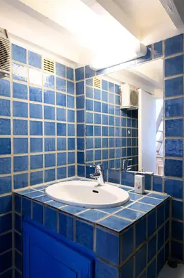 a bathroom with blue tiled walls and a sink at Cocon provençal dans le centre historique in Aix-en-Provence