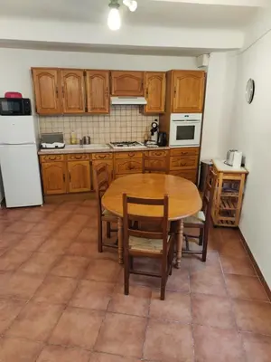 a kitchen with wooden cabinets and a table and chairs at Apt capitale du Luberon appartement 3 chambres 4 lits in Apt