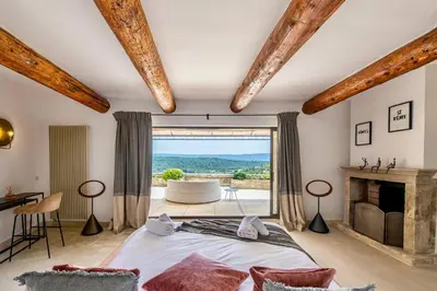 a bedroom with a bed and a large window at Vue Dexception Gordes in Gordes