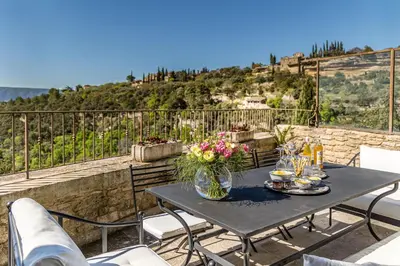 a table with flowers on top of a balcony at Vue Dexception Gordes in Gordes