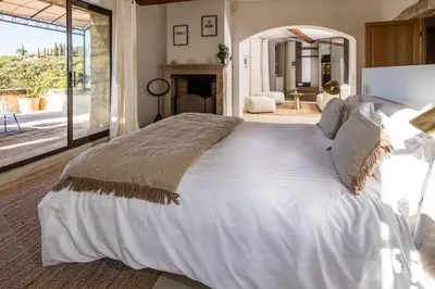 a large white bed in a bedroom with a fireplace at Vue Dexception Gordes in Gordes