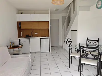 a kitchen and a living room with a table and chairs at La provençale in Saint-Saturnin-lès-Avignon