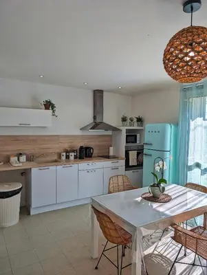 a kitchen with a table and a blue refrigerator at L'instant sorgue in LʼIsle-sur-la-Sorgue