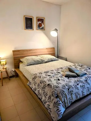 a bedroom with a bed with a lamp on it at L'instant sorgue in LʼIsle-sur-la-Sorgue