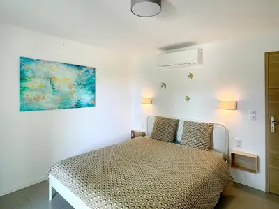 a bedroom with a bed and a painting on the wall at Au calme dans la campagne Aixoise, entouré de cyprès in Aix-en-Provence