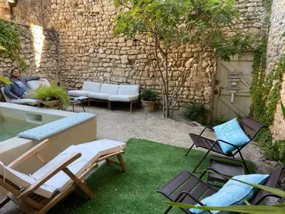 a man sitting on a couch in a yard with chairs at La Capucine in Cavaillon
