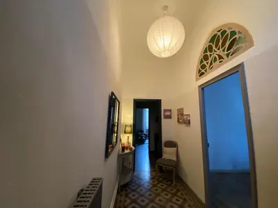 a hallway with a room with a door and a table and chair at La Capucine in Cavaillon